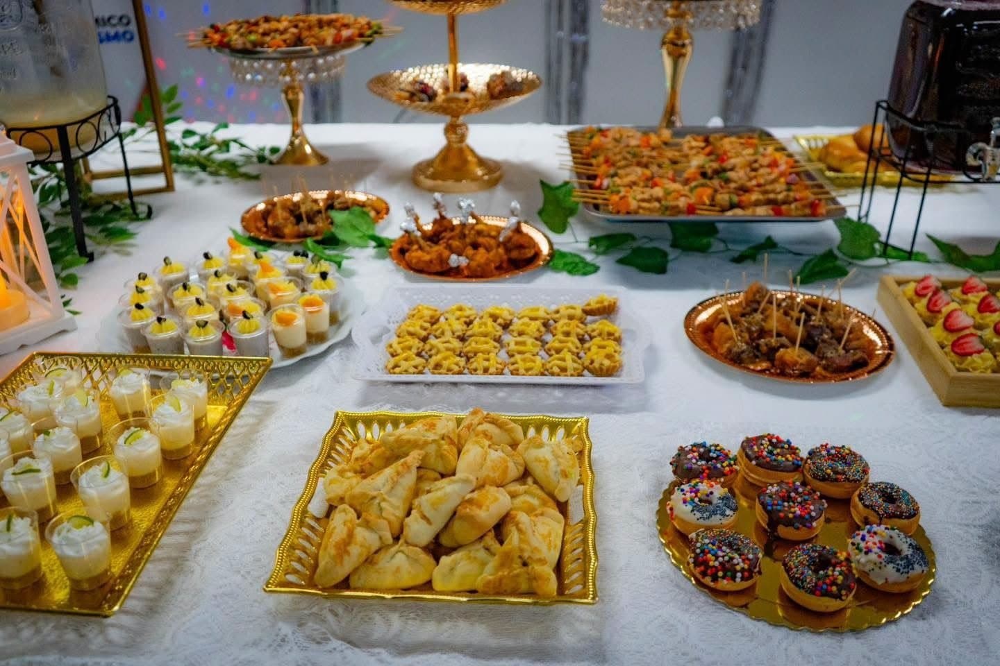 Mesa de bocaditos dulces y salados sobre bandejas doradas